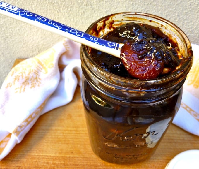 Homemade dried fruit compote in glass mason jar with spoon.