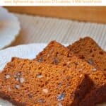 Fresh sliced pumpkin bread with raisins and nuts on a white plate.