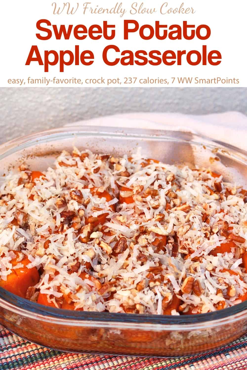 Slow cooker sweet potato apple casserole topped with chopped pecans and shredded coconut in glass serving dish.