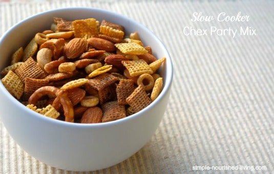 Crock Pot Chex Party Mix (mini pretzels, almonds, peanuts, crispy cereal) in a Small White Bowl