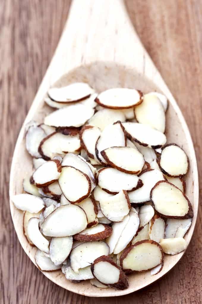 Sliced almonds in a large wooden spoon