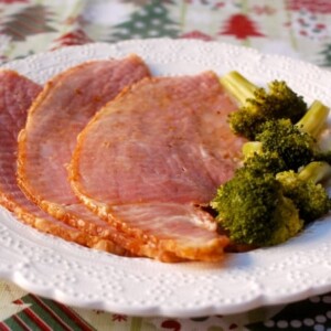slices of spiral cut ham on a plate with broccoli alongside