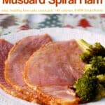 Slow cooker orange honey mustard slow cooker spiral ham with broccoli on white dinner plate.