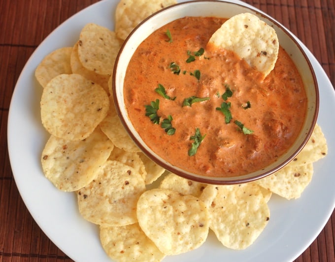 Chili cheese dip in a bowl surrounded by tortilla chips