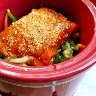 red crock pot with mixed asian vegetables and salmon fillets