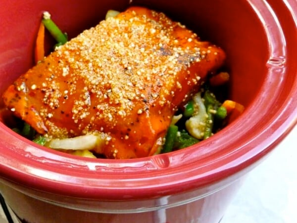 red crock pot with mixed asian vegetables and salmon fillets