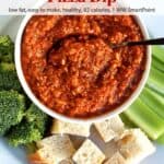 Pizza dip in a small dish on a platter with broccoli florets, bread cubes and celery sticks for dipping