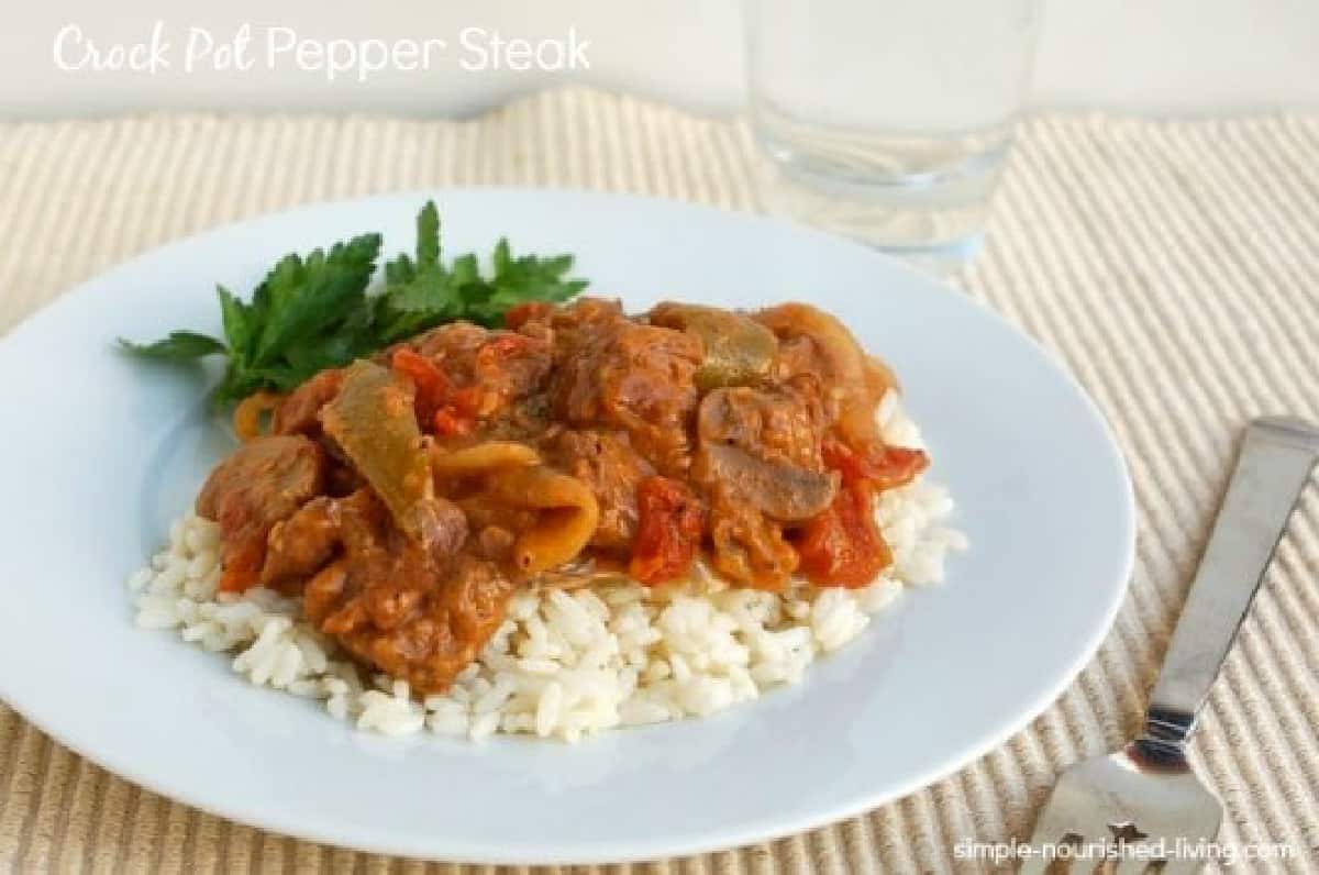 Crock pot pepper steal over white rice on dinner plate with fork.