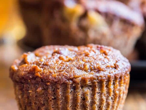 Banana Bran Muffin up close with a hand grabbing another muffin in the background