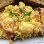 Close up scrambled eggs salmon dill garnish