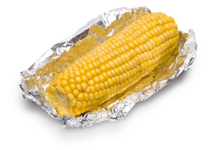Corn on the cob wrapped in a piece of aluminum foil.