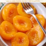 Slow cooker peaches in white serving dish with fork.