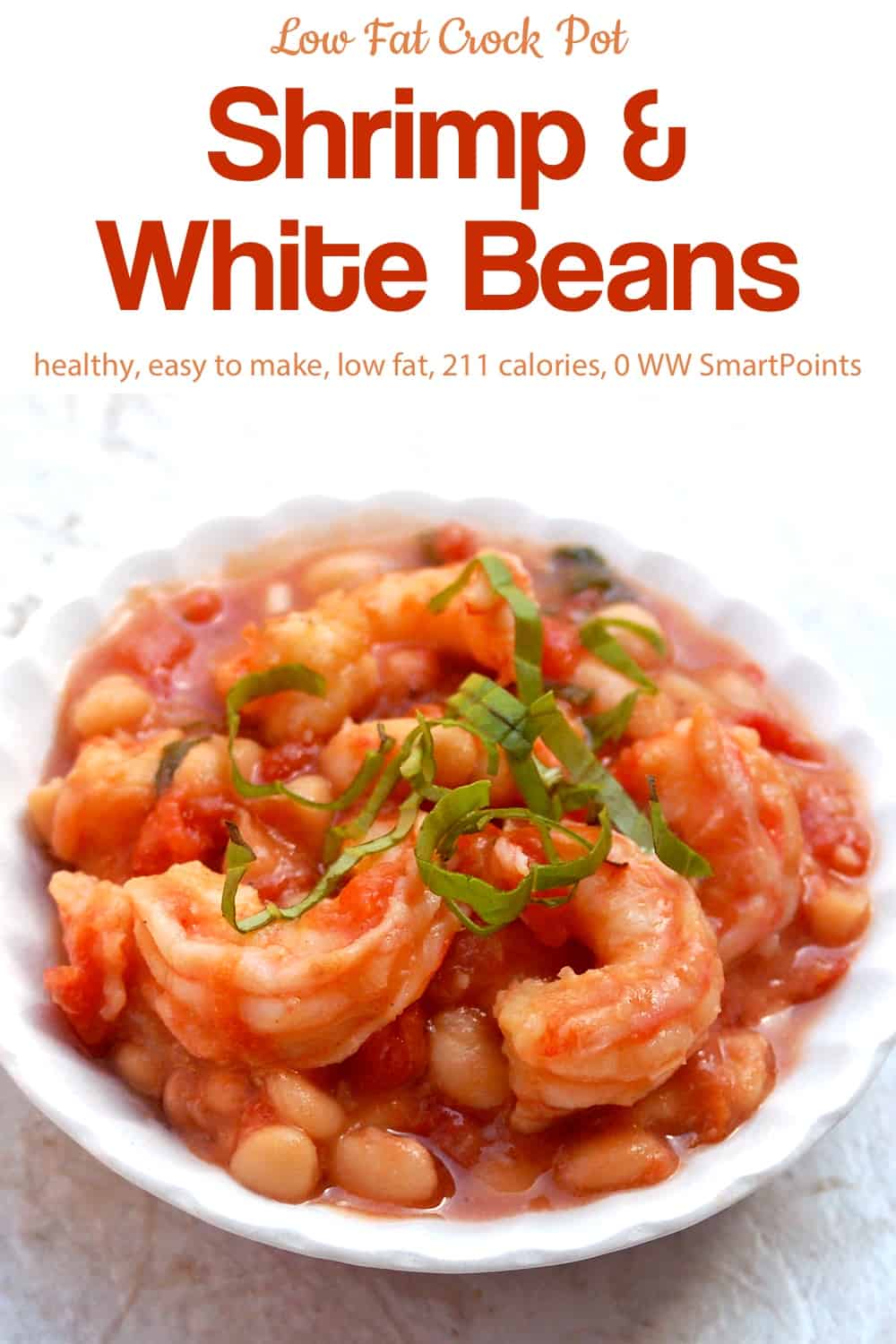 White beans with shrimp in light tomato sauce topped with sliced fresh basil in white bowl.