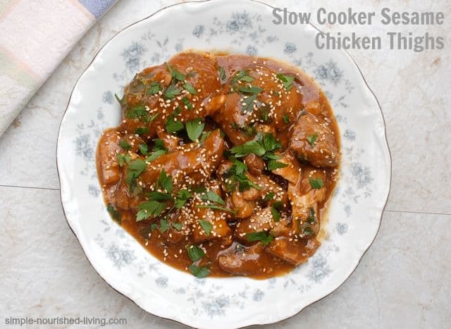 Slow Cooker Sesame Chicken Thighs topped with fresh cilantro in white bowl.