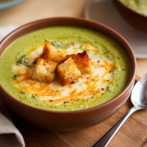 heavy brown ceramic bowl with broccoli cheese soup garnished with croutons