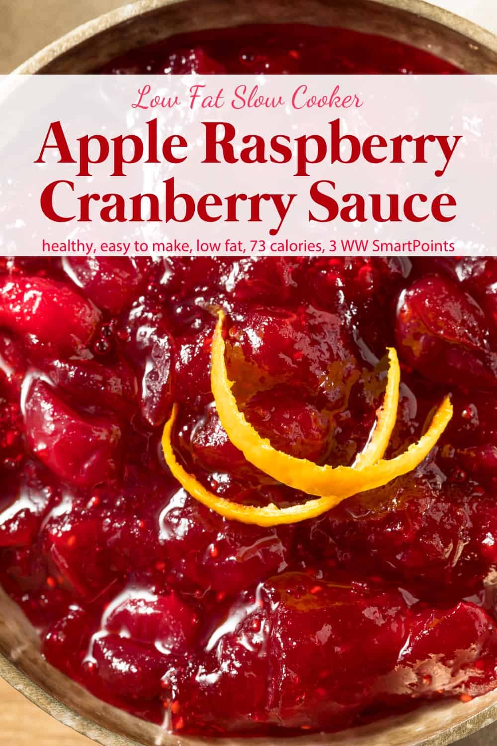 Slow cooker apple raspberry cranberry sauce with fresh orange peel up close.