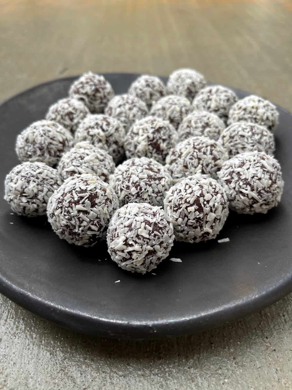 Easy Coconut Almond Truffles made healthier on a brown ceramic plate.