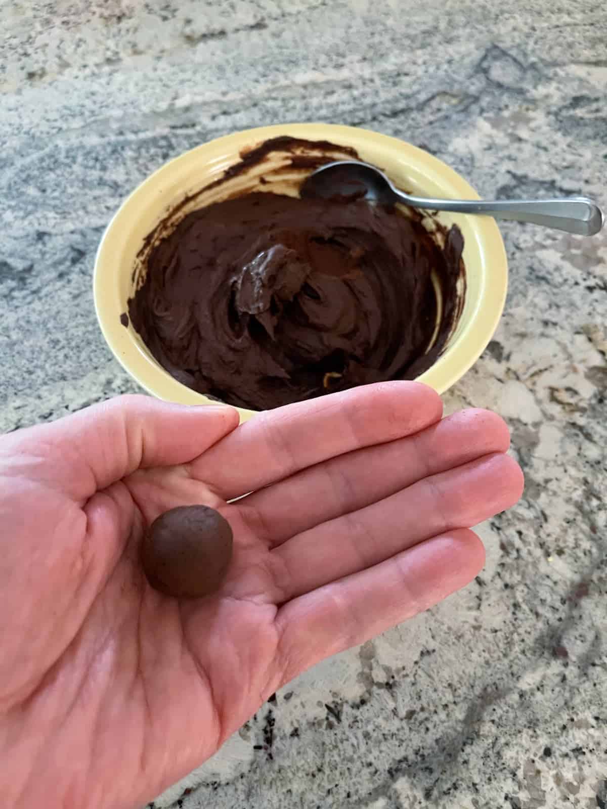 Rolling chocolate almond truffles.