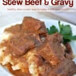 Stew beef with gravy over mashed potatoes on dinner plate
