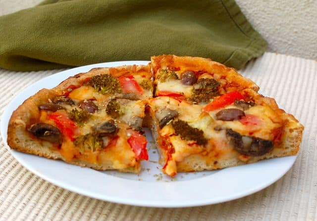 Vegetable pizza on white plate.