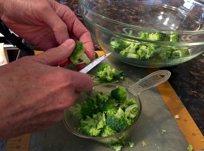 Cutting broccoli into florets close up