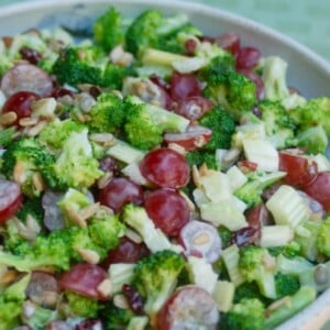 skinny broccoli salad in a ceramic bowl with green background
