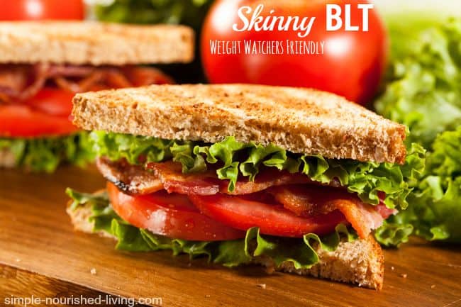 Closeup of BLT on toast cut in half with tomato in background.
