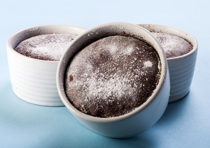 Three individual chocolate soufflés dusted with powdered sugar