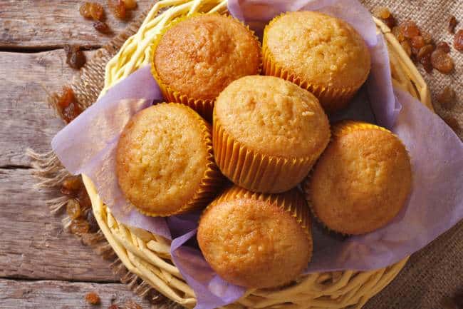 2-Ingredient Pumpkin Spice Cake Mix Muffins in basket on wooden table.