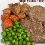Weight pot roast with potatoes, carrots, peas on plate close up