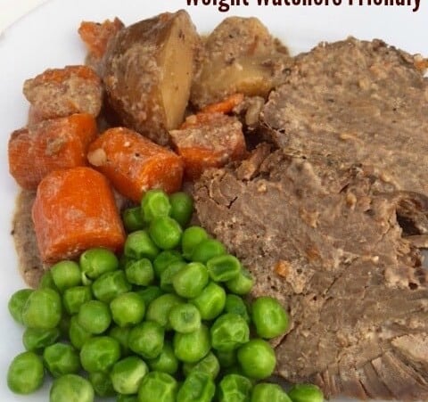 Weight pot roast with potatoes, carrots, peas on plate close up