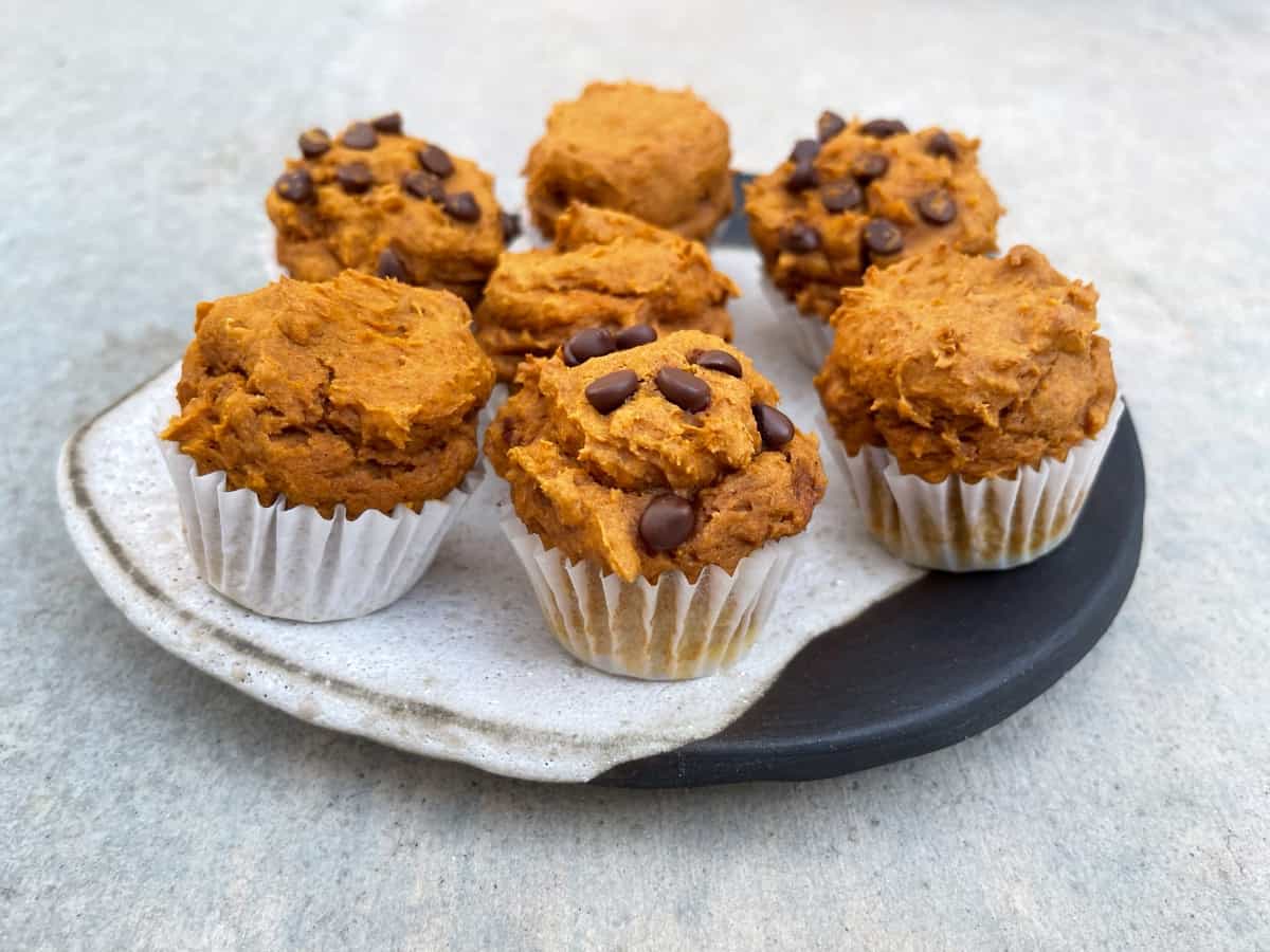 Plain and chocolate chip mini pumpkin spice muffins on small ceramic plate.