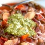 Bowl of vegetarian minestrone soup topped with basil pesto