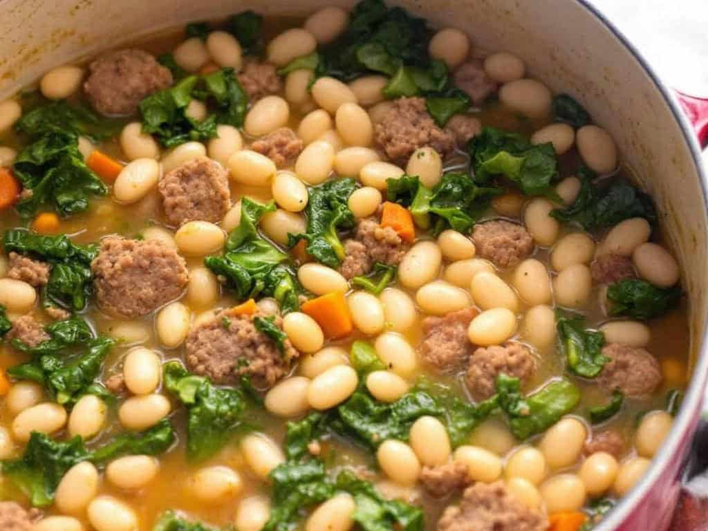 a pot of italian sausage and white bean soup with greens