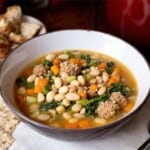 bowl of italian sausage and white bean soup with escarole in a large bowl