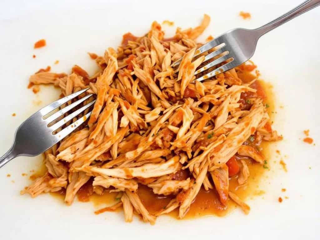 shredding salsa chicken with two forks