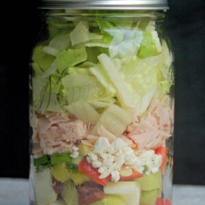 Greek Turkey Feta Salad in a Jar from side black background