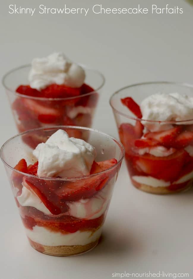 3 clear glasses or strawberry cheesecake parfait on white background.