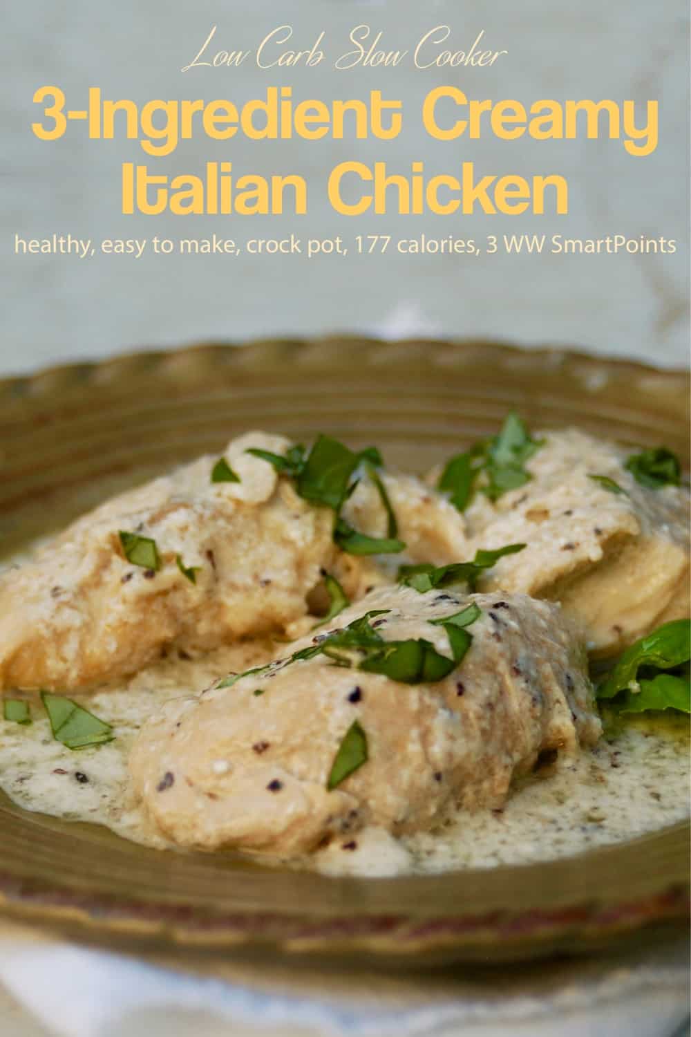 Slow cooker 3-ingredient creamy italian chicken garnished with fresh chopped basil on serving platter.