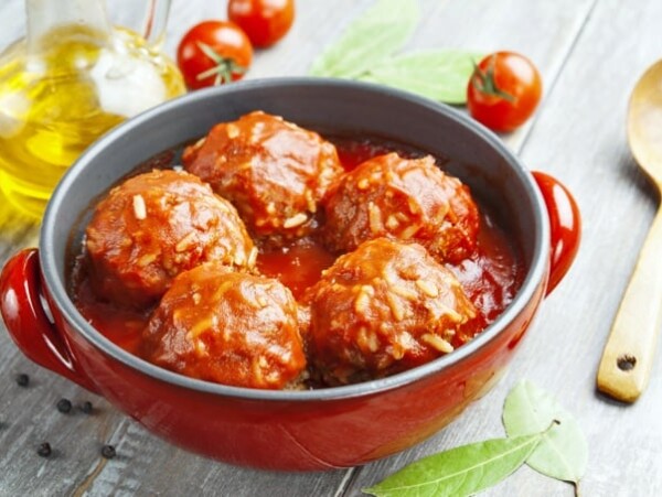 Meatballs with rice and tomato sauce in a red pot