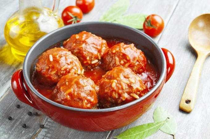 Meatballs with rice and tomato sauce in a red pot.