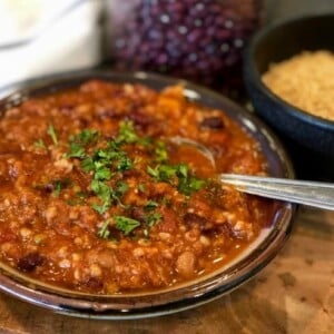 pottery bowl of vegetarian chili close up beans bulgar background