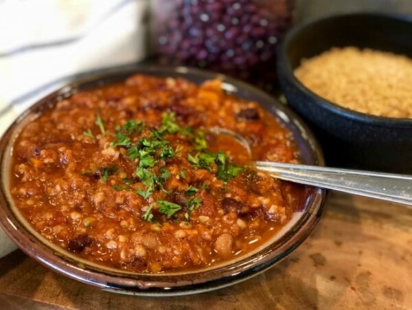 pottery bowl of vegetarian chili close up beans bulgar background