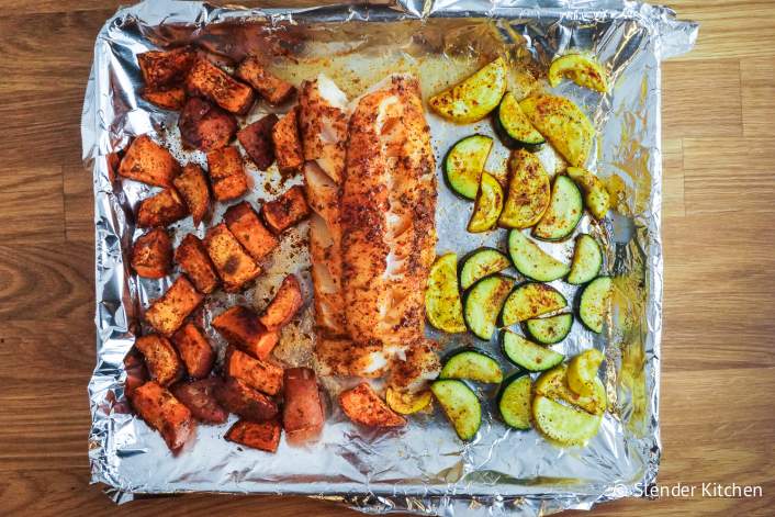 sheet pan lined with foil with salmon sweet potatoes and zucchini slices