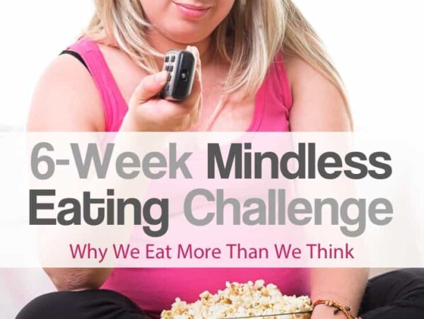 Woman in pink tank top sitting crossed legged with large bowl of popcorn in her lap clicking the remote control