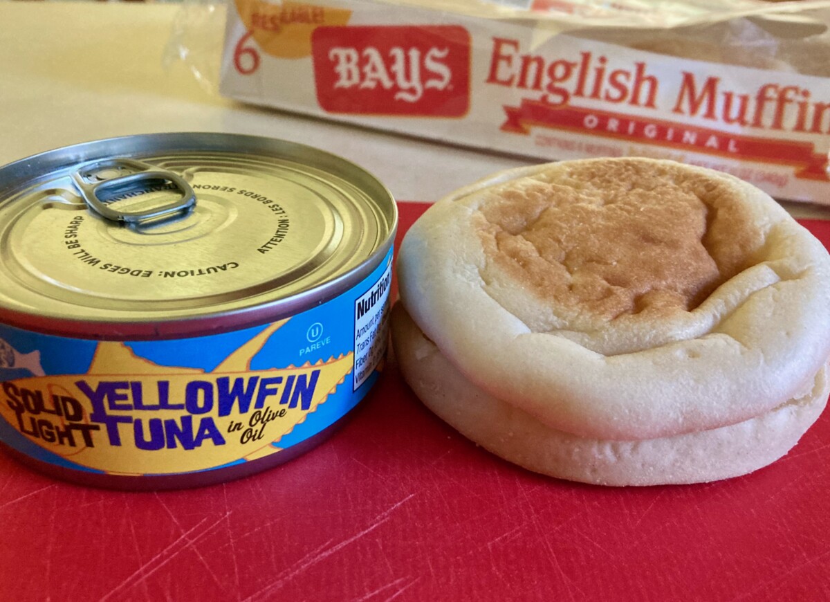 Can of Tuna & English Muffin on Red Cutting Board with Package of English Muffins Behind