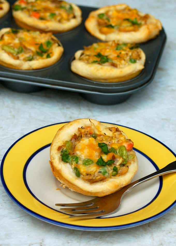 Mini Chicken Pot Pie on a small plate with fork and muffin tin with chicken pot pies in background