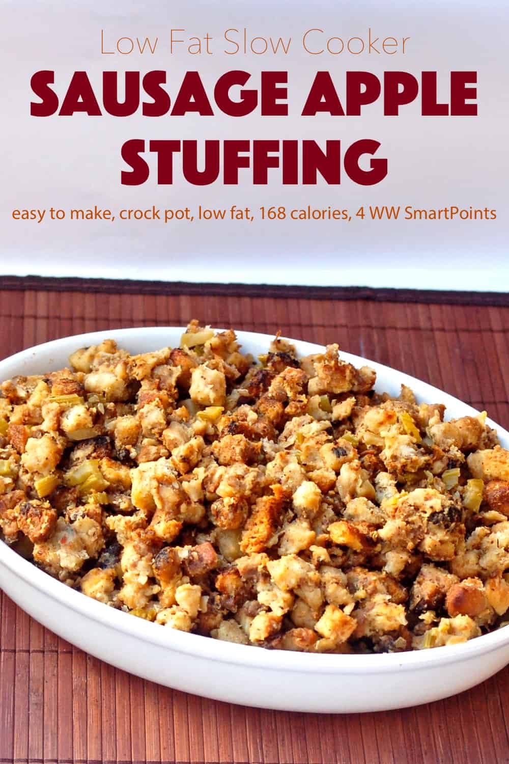 Slow Cooker Sausage Apple Stuffing in white serving dish on wooden mat.