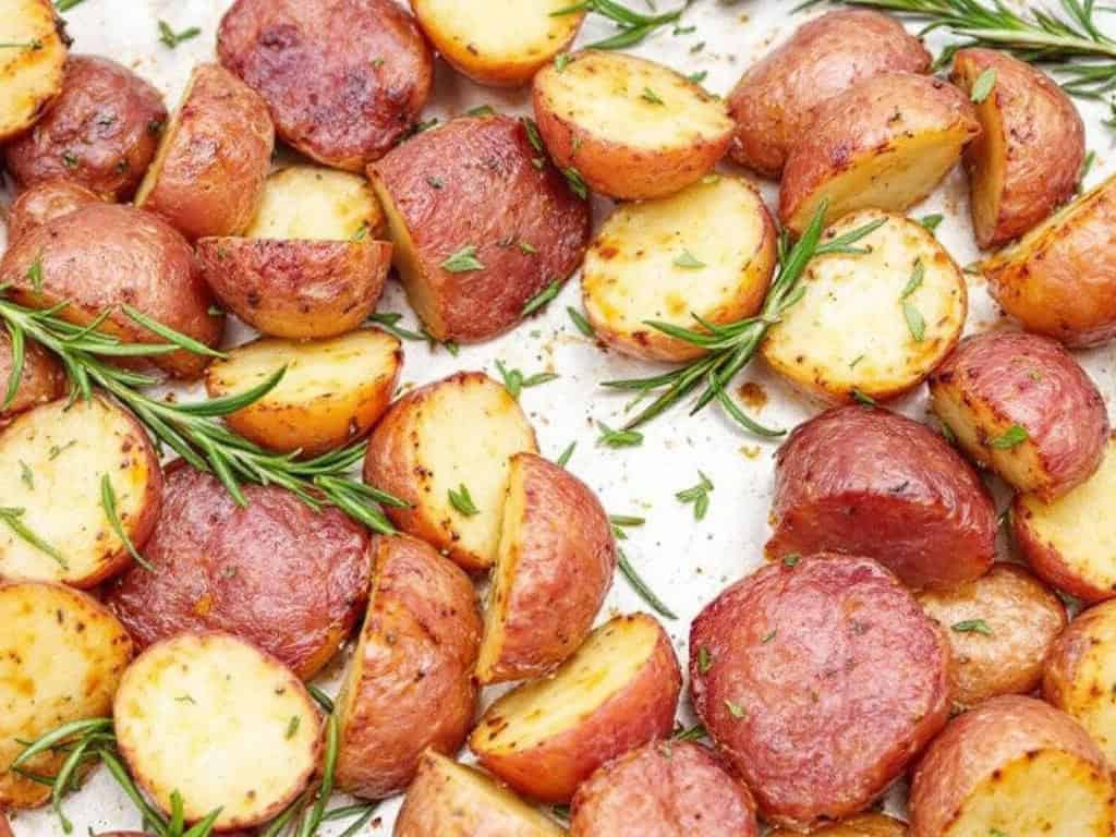 red skinned potatoes and rosemary on a sheet pan