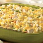 Hearty Creamy Chicken Noodle Casserole topped with melted cheese in an oblong pale green pottery dish